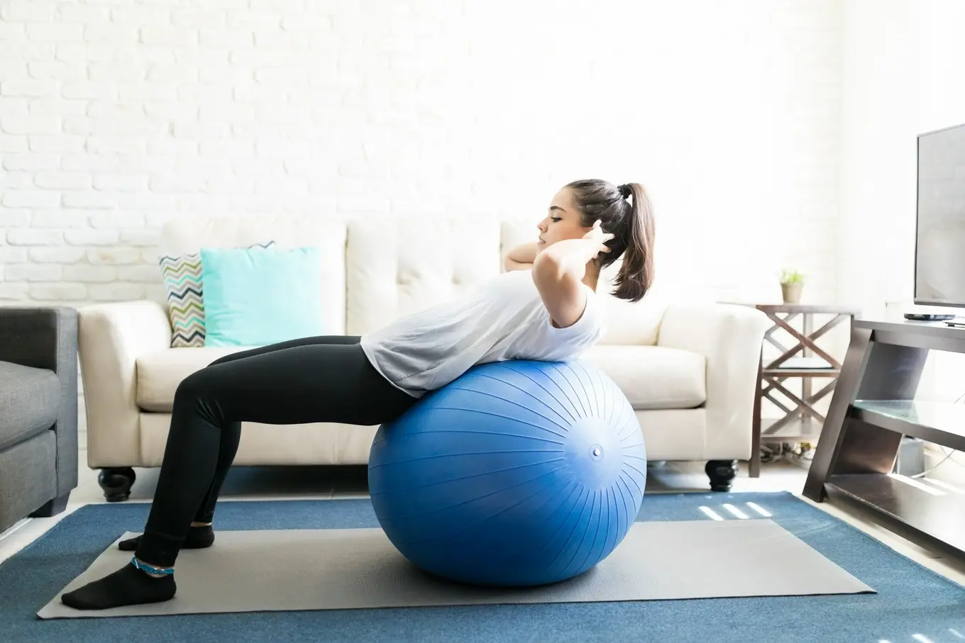 młoda kobieta ćwicząca na piłce fitness